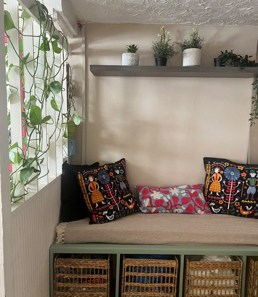 The cosy café lounge corner at Art of Beauty Café with cushions and plants